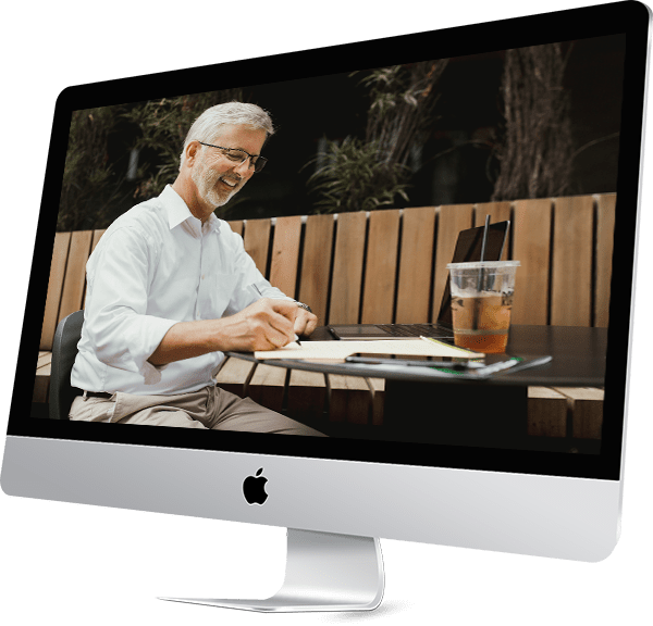 Doug Mottet working at table on screen of imac